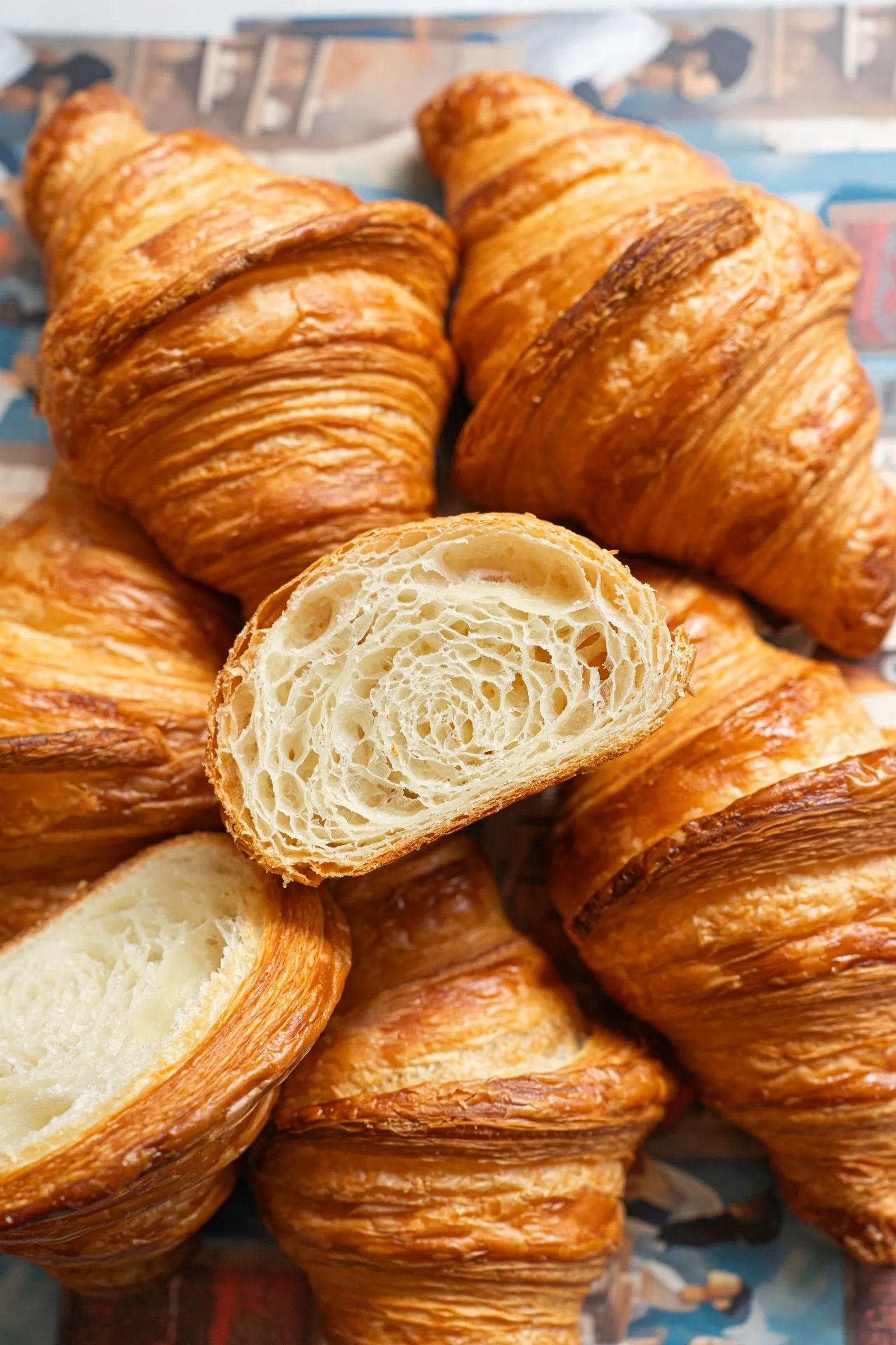 A baked croissant torn open to show its honeycomb layers