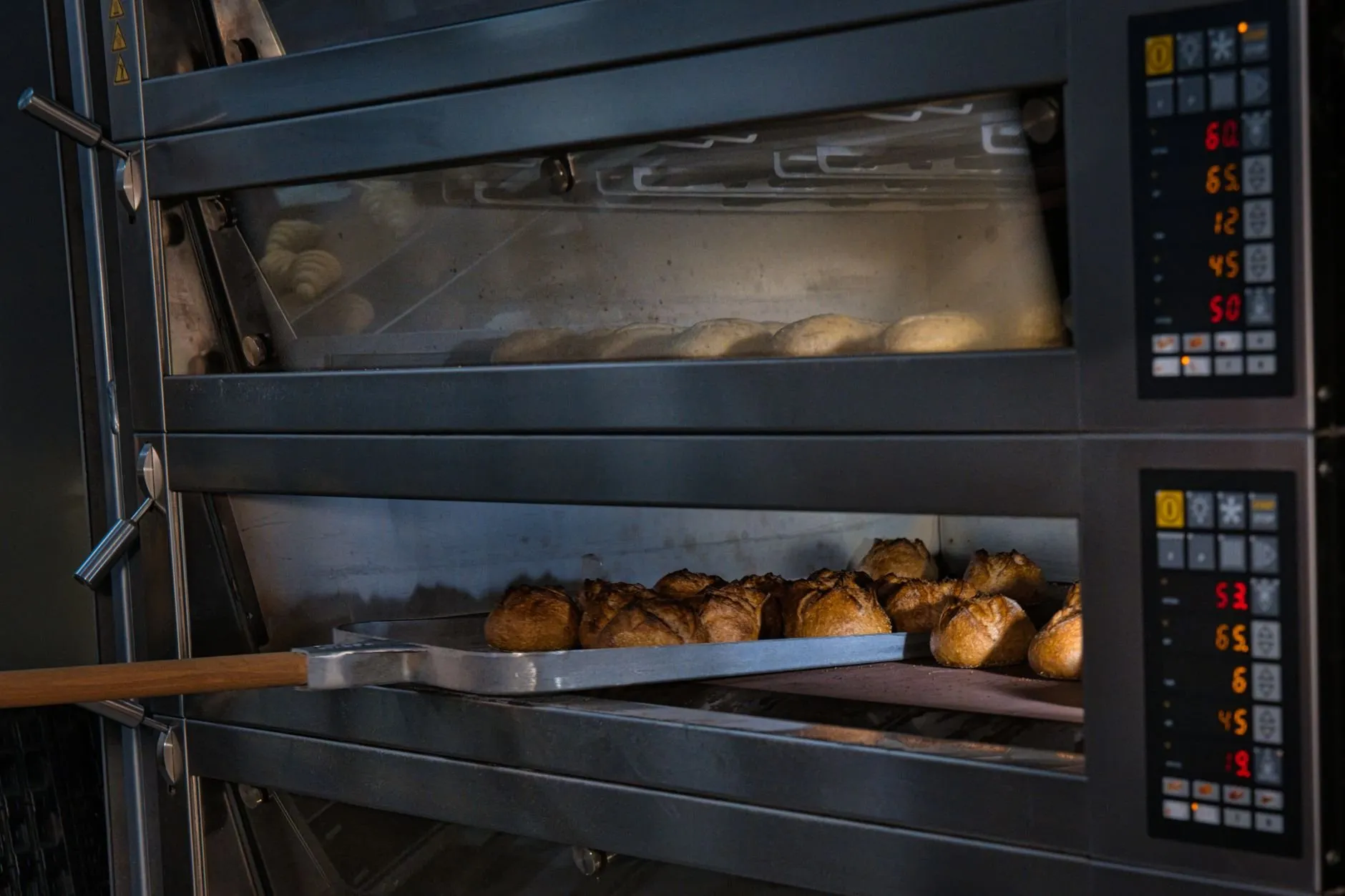The two-deck bakery oven with a peel of rolls going in