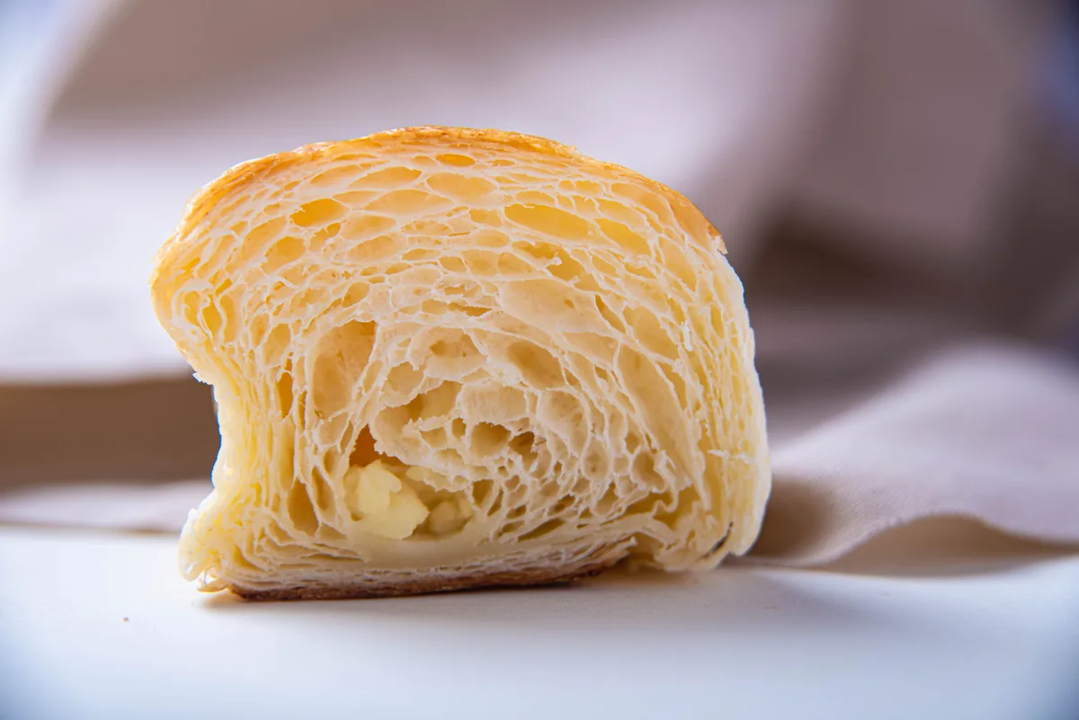 Cross-section of a croissant showing many thin flaky laminated layers.